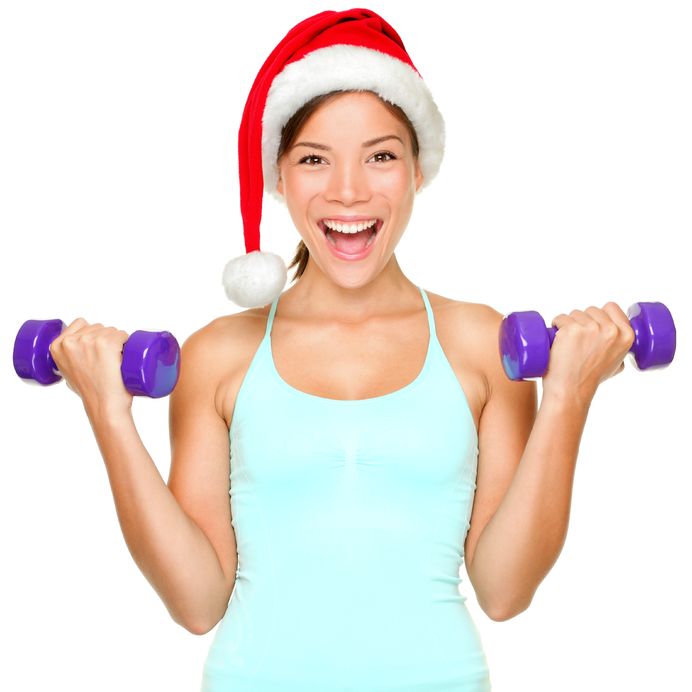 Woman in Santa Hat Holding Dumbbells